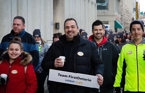 Smiling Group in Parade Holding Team FirstOntario Sign